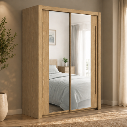 A tall wooden wardrobe with two mirrored sliding doors stands in a bedroom. The wardrobe has a light oak finish and is shown in a styled room with a bed, curtains, and a potted plant visible in the mirrored doors.