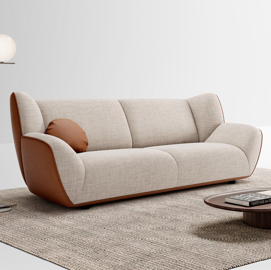 Beige sofa with brown armrests in a minimalistic living room setting.