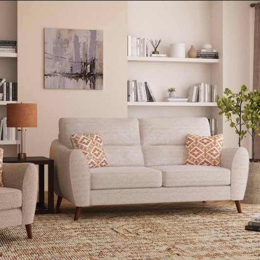 Living room with beige armchair and sofa, decorative pillows, and a cityscape painting.