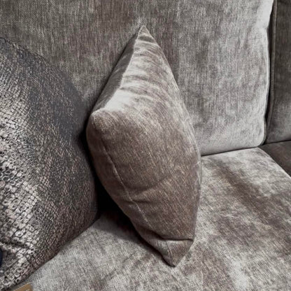 Gray textured sofa with a single pillow on a plain background